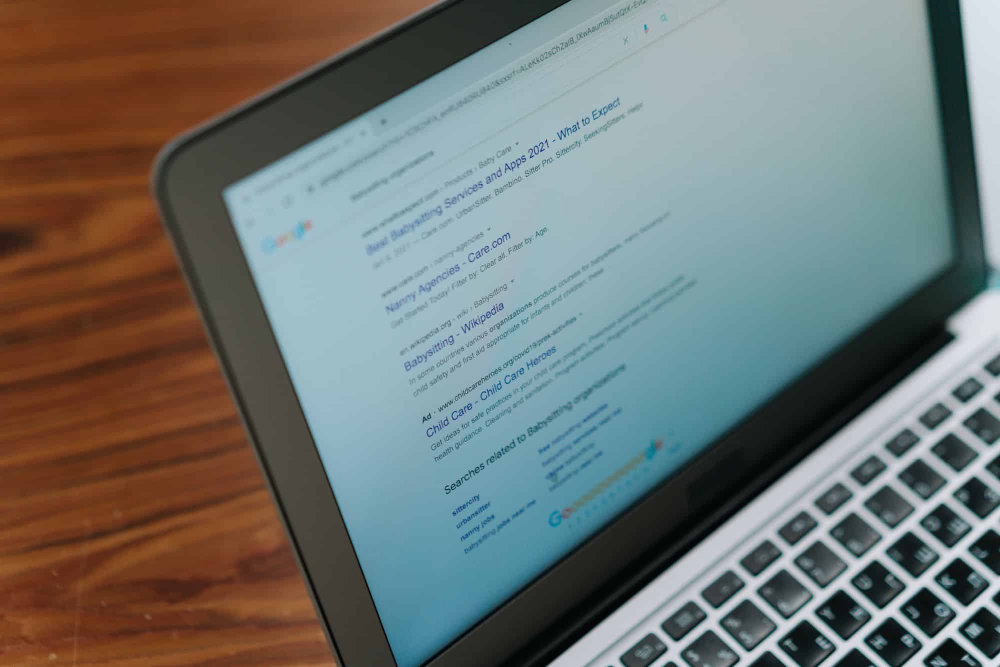 A laptop displays a Google search page.